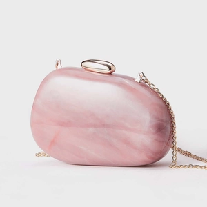 Detail of pink marble acrylic clutch with rose gold clasp and chain strap