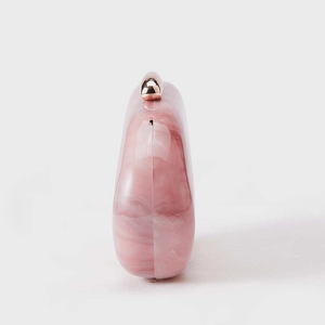 Detailed side view of pink marble acrylic evening clutch with premium metal clasp