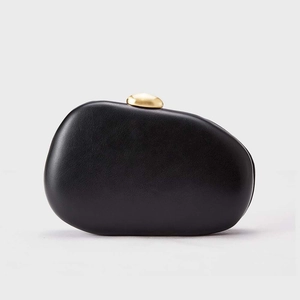 Pochette minimaliste noire en forme de galet avec fermoir doré sur fond de studio gris
