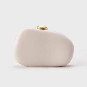 Gros plan sur l'embrayage beige galet avec un fermoir élégant en métal doré en forme de haricot