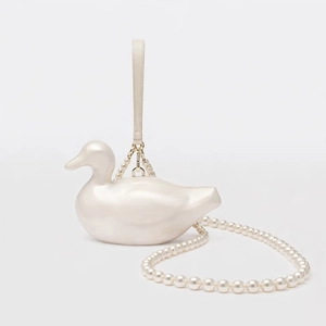 Detail of pearlescent duck-shaped acrylic bag with pearl strap and leather handle