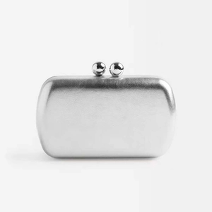 Detailed macro view of silver metallic texture and twin ball clasp on clutch bag
