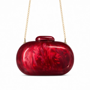 Macro shot of red marble acrylic shell clutch bag with gold chain and polished finish