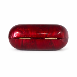 Detail of red marble acrylic evening clutch with luxury gold metal hardware hinge