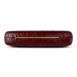 Detailed close-up of dark wine red crocodile pattern leather with gold metal hinge detail