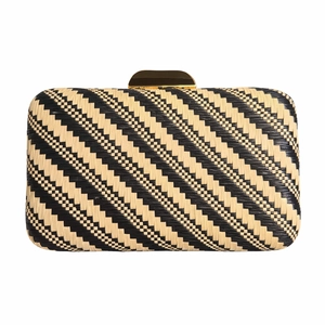 Detail of woven evening clutch featuring black and beige geometric patterns and gold clasp