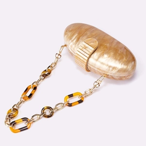 Elegant oval acrylic evening bag with marble texture and tortoise link chain strap