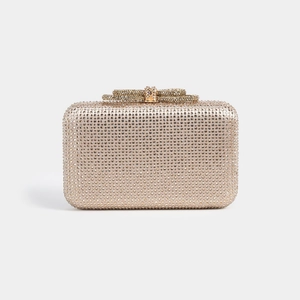 Detailed view of champagne gold evening clutch featuring dense rhinestones and bow clasp