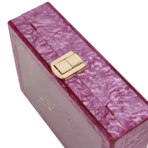 Détail macro d'une pochette de soirée en acrylique violet marbré avec fermoir doré