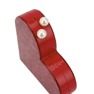 Detail of red heart acrylic evening bag with marble texture and double pearl clasp closure