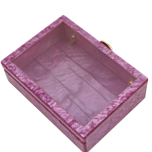 Détail de la pochette de soirée en acrylique marbré rose avec fermoir en métal doré