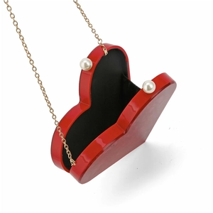 Red heart-shaped acrylic clutch bag with gold chain and large pearl ornaments