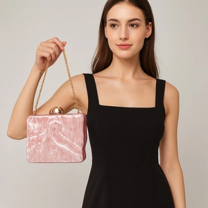 Pink marble acrylic clutch bag with gold clasp shown on a model in a black dress