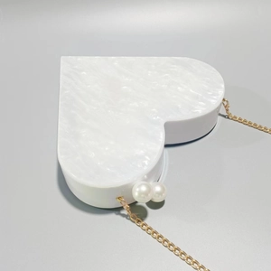 Heart-shaped pearlescent acrylic evening bag with pearl clasp and gold chain strap
