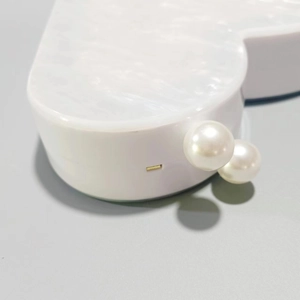 Elegant white marble acrylic heart-shaped clutch bag with pearl clasp and gold hinges