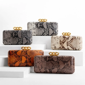 Detailed view of luxury snake print clutch bags with gold interlocking chain clasps