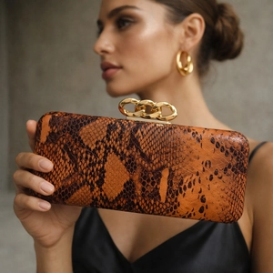 Orange-brown python texture rectangular clutch with bold gold chain lock for evening wear