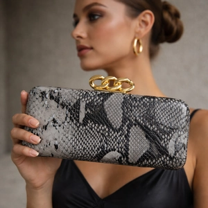 Fashionable snakeskin crossbody bag with large gold chain link handle in elegant clutch style