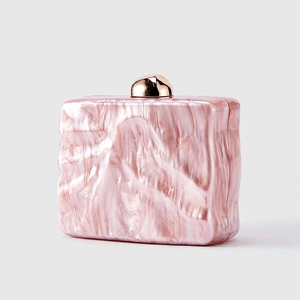 Detailed macro view of pink marble texture on acrylic evening clutch with gold ball lock