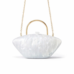 Detail of white marble acrylic clutch featuring gold handle and elegant chain strap