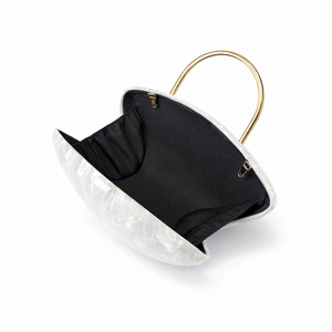 Detail view of acrylic evening clutch with marble texture and gold ring handle