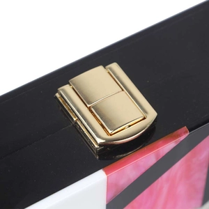 Detailed view of acrylic clutch bag with marble pattern texture and golden metal lock