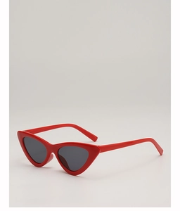 Detail of red vintage cat eye sunglasses with dark gray lenses on a minimalist background