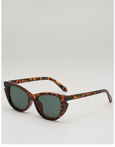Détail de lunettes de soleil œil-de-chat avec monture écaille et verres vert foncé