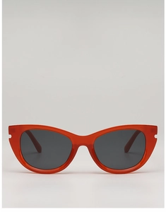 Détail de lunettes de soleil œil de chat rouges avec monture translucide et encoches