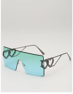 Close-up of rimless gradient lenses with metallic heart detail on oversized sunglasses