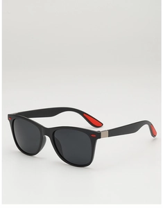 Détail de lunettes de soleil carrées noires avec branches antidérapantes rouges et verres