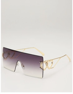 Detail of gold metal temples with hollow heart design on oversized rimless sunglasses