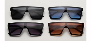 Flat lay of oversized shield sunglasses in grey, blue, purple and tea brown lenses