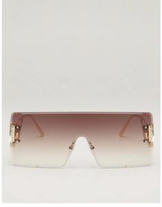 Detail of rimless oversized sunglasses with brown gradient lenses and golden hinges