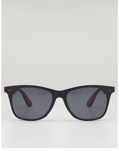 Détail de lunettes de soleil carrées noires avec des accents rouges sur les branches