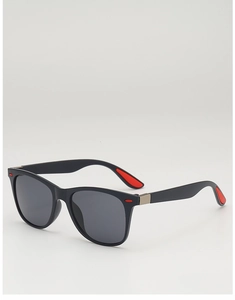 Détail de lunettes de soleil carrées noires avec des accents rouges sur la monture