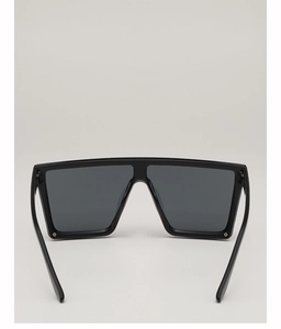 Close-up of black oversized square sunglasses with polished frames and dark lenses