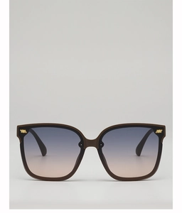 Detail of square oversized sunglasses with brown frame and gradient lenses featuring gold logo
