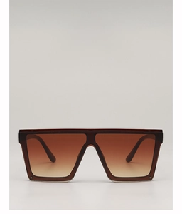 Detail view of oversized square sunglasses with brown gradient lenses and translucent frames