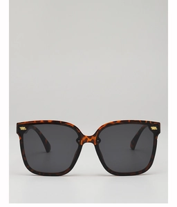 Detail of tortoise shell square sunglasses with gold metal studs and dark lenses