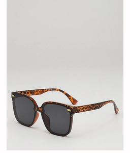 Detail of tortoise shell sunglasses with gold accents and textured woven pattern temples