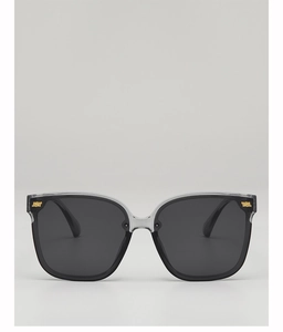 Detail of square oversized sunglasses with two-tone grey frame and gold metal accents