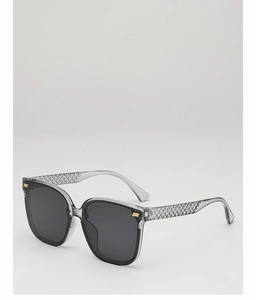 Detail of grey translucent sunglasses featuring woven texture temples and gold accents