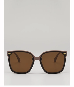 Detail of square oversized sunglasses with brown lenses and golden metal accents
