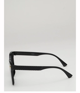 Detail of square black sunglasses temple with grid texture and gold metal ornament