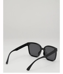 Detail view of black square sunglasses featuring woven texture on the temple and dark lenses