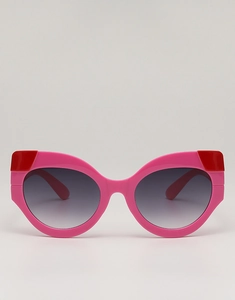 Close-up of pink cat eye sunglasses with bold red contrast corners and gradient lenses