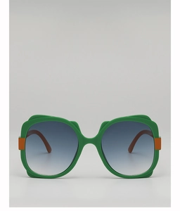 Detail of green oversized sunglasses with gradient blue lenses and orange hinge decor