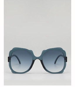 Close-up of oversized translucent navy frame sunglasses with unique wavy top design and blue gradient lenses