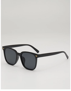 Detail of square black sunglasses with gold metal accents and dark grey lenses